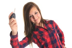 A teen holding key in front of a white background